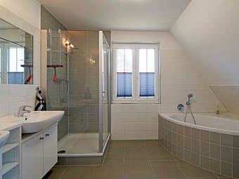 Das große Bad mit Eckbadewanne, Dusche und WC im Dachgeschoss